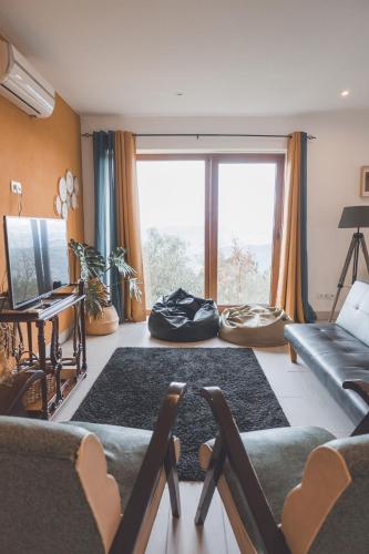 a living room with a couch and a large window at Fraga`s House - Douro e Natureza in Coura