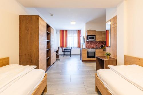 a hotel room with two beds and a kitchen at Wels Inn Hotel in Wels