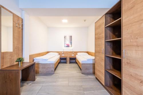 a room with two beds and a table and shelves at Wels Inn Hotel in Wels