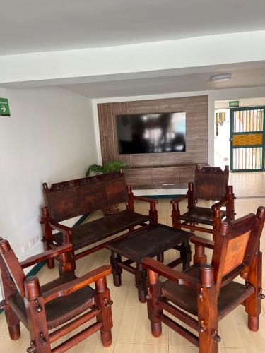 a room with chairs and a table and a tv at Colina del Sol Hotel Hacienda in Quimbaya