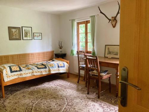 een slaapkamer met een bed, een bureau en een raam bij Dvůr Metlice in Rožmberk nad Vltavou