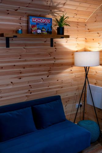 a living room with a blue couch and a lamp at Mount Ephraim Glamping Pods in Hernehill