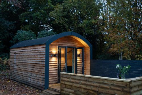 a small wooden shed with a blue roof at Mount Ephraim Glamping Pods in Hernehill