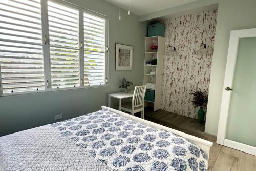 a bedroom with a bed and a desk and a window at Villatoña, 4BR, Beach house with pool in Aguada