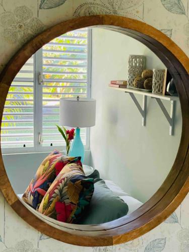 a circular mirror in a room with a bed and a lamp at Villatoña, 4BR, Beach house with pool in Aguada