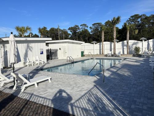 a shadow of a person standing next to a swimming pool at NEW Pool 4 BDR Golf Cart in Inlet Beach