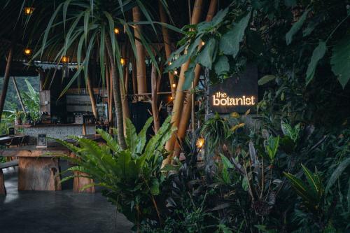 a restaurant with plants and a sign that says the botanical at Desa Eko in Munduk