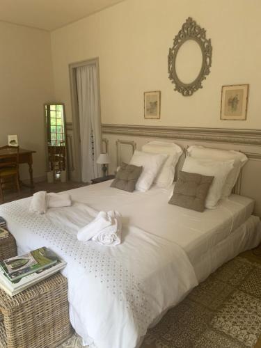 une chambre avec un grand lit blanc avec un miroir dans l'établissement Le 22, à Nontron