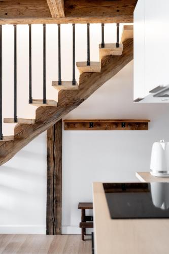 a staircase in a kitchen with wood and white walls at La ferme d'Hauteluce - Chalets in Hauteluce