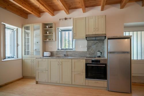 a kitchen with white cabinets and a stainless steel refrigerator at Neapolis Oasis - Lower House in Neapolis
