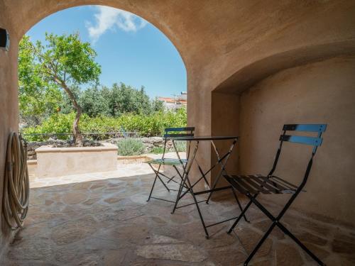 two chairs sitting on a patio with an archway at Neapolis Oasis - Lower House in Neapolis