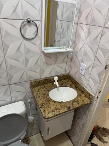 a bathroom with a sink and a toilet at Casa de temporada a 10 metros da praia in Cabo Frio