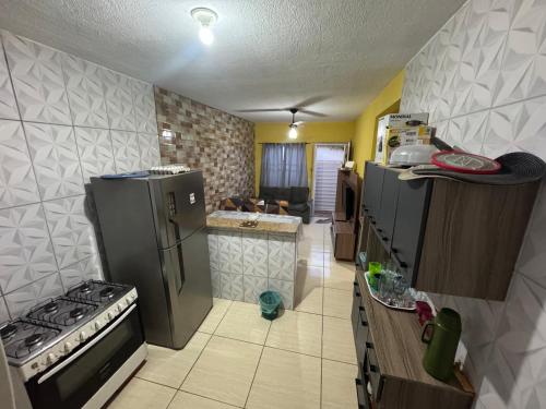 a kitchen with a refrigerator and a stove in it at Casa de temporada a 10 metros da praia in Cabo Frio