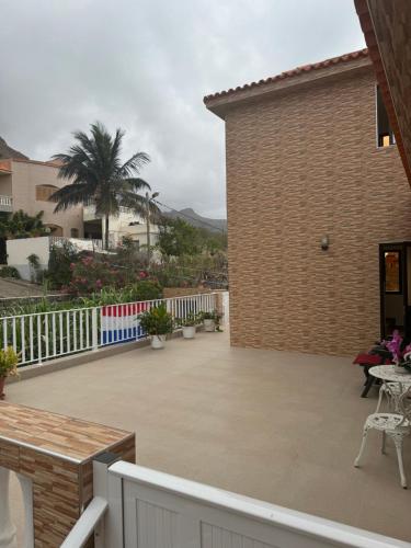 a patio with a white fence and a building at Casa Carveiros Panoramic 360 in Tarrafal