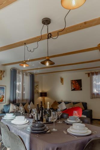 une salle à manger avec une table avec des assiettes et des verres à vin dans l'établissement Hébergement 4 étoiles Accès Pied des Pistes en Navette Gratuite, à Saint-Chaffrey