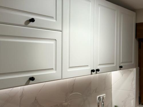 a kitchen with white cabinets and a sink at Apartments 16th Street in Mostar