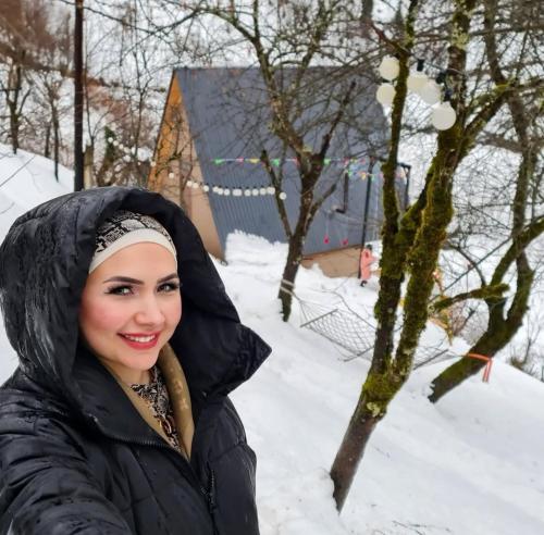 a woman in a black jacket in the snow at Eco cottage sunrise merisi in Merisi