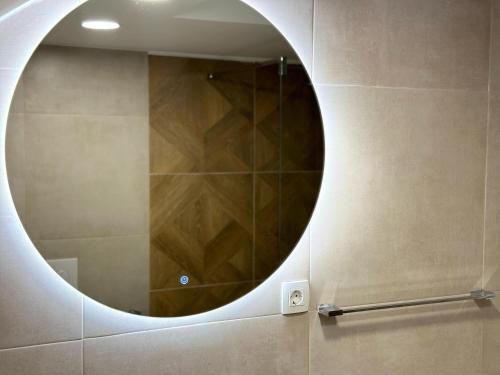 a bathroom with a round mirror on the wall at Apartments 16th Street in Mostar