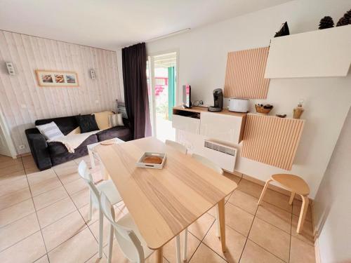 une cuisine et un salon avec une table et des chaises dans l'établissement Appartement en résidence, à Moliets-et-Maa