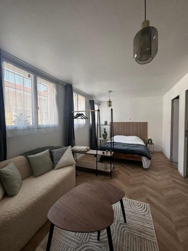un salon avec un canapé et un lit dans l'établissement Petit appt cosy et moderne, à Perpignan