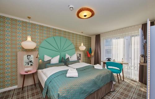 um quarto com uma cama grande e uma colcha verde em Bernstein Hotel "50`s Seaside Motel" em Büsum