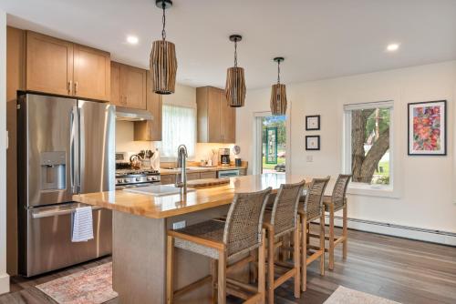 a kitchen with wooden cabinets and a kitchen island with chairs at Lakeshore Vermont in Colchester