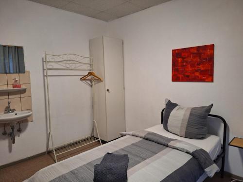 a bedroom with a bed and a sink and a mirror at Zimmer G in Mönchengladbach