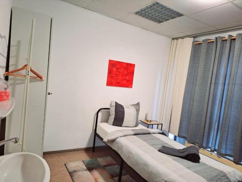 a room with two beds and a sink and a window at Zimmer G in Mönchengladbach
