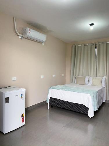 a bedroom with a bed and a air conditioner at Quartos a 1km do centro de Pirenópolis in Pirenópolis