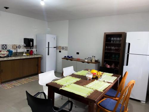 a kitchen with a table with chairs and a refrigerator at Quartos a 1km do centro de Pirenópolis in Pirenópolis