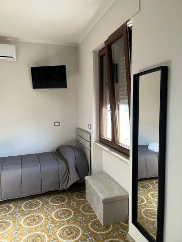 a small room with a bed and a mirror at La Stazione bed and breakfast in Boiano