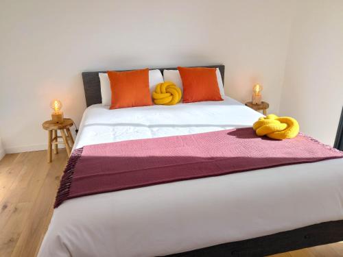 un lit avec deux animaux farcis jaunes assis sur lui dans l'établissement Villa Onébien, à Gujan-Mestras