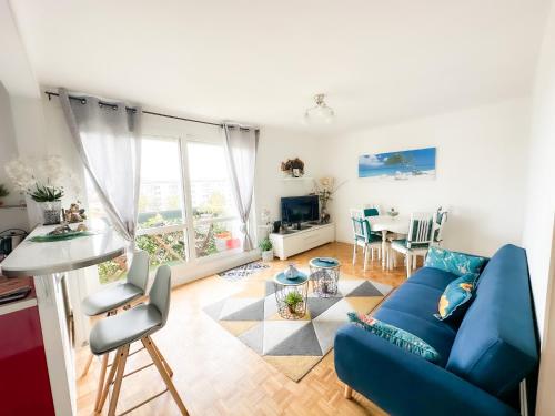a living room with a blue couch and a table at - Le COSY GARDEN - Proche RER A et E - Paris Disney - Parking et WIFI Gratuit ! Family SPECIAL OFFER in Champigny-sur-Marne