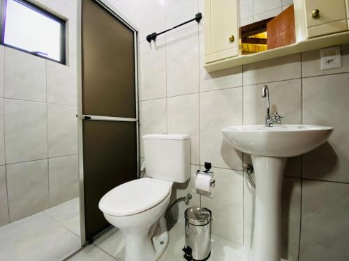 un baño con inodoro y lavabo en Apartamento com vista panorâmica em Bombas, en Bombinhas