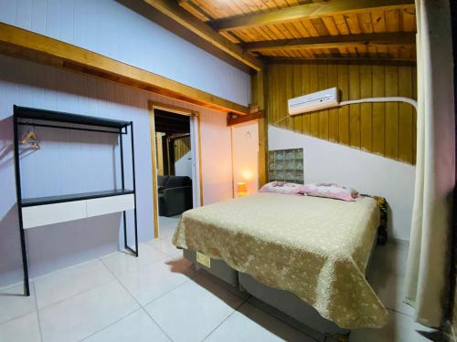 Un dormitorio con una cama y un escritorio. en Apartamento com vista panorâmica em Bombas, en Bombinhas