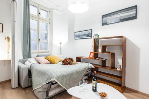 Cette chambre comprend un lit et une table avec un miroir. dans l'établissement FEEL HOME - Poissonnerie, à Nice