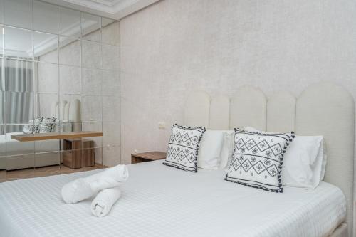 una camera da letto con un grande letto bianco con cuscini di Luxurious Condo in Tangier a Tangeri