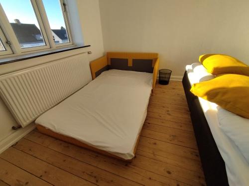 a small room with two beds and a window at Fjeldgaard Rug 1sal in Odense