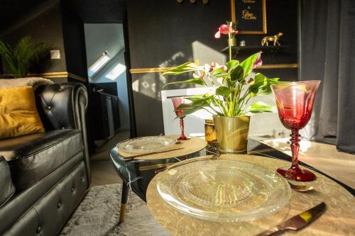 a table with two glasses and a vase on it at Le Glam Divin in Nantes