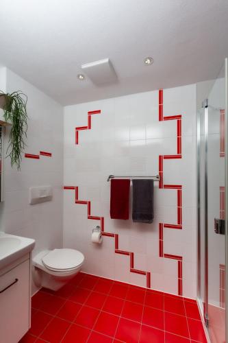 a bathroom with a red and white pattern on the wall at Ferien im Paradies - Wohnung Vera in Höchst