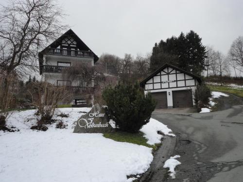 a house in the snow with a sign in front of it at Haus Volkesbach in Liesen