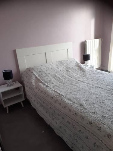 - une chambre avec un lit doté d'un couvre-lit blanc et de 2 lampes dans l'établissement T2 calme, stationnement gratuit, autoroute à proximité, plage à 10km, à Marseille