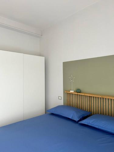 a bedroom with a large bed with blue pillows at Casa I Merletti in Lunano