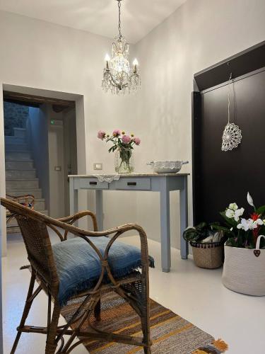 a dining room with a table and a chair and a chandelier at Casa I Merletti in Lunano