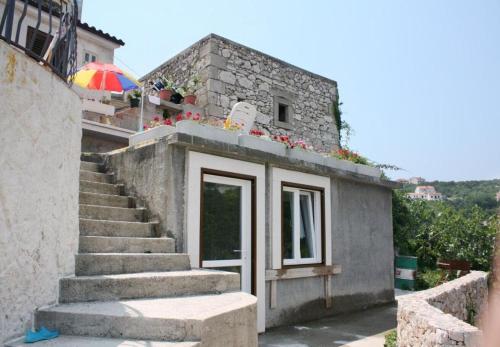 a building with stairs and an umbrella on top of it at House Bernardica in Vrbnik
