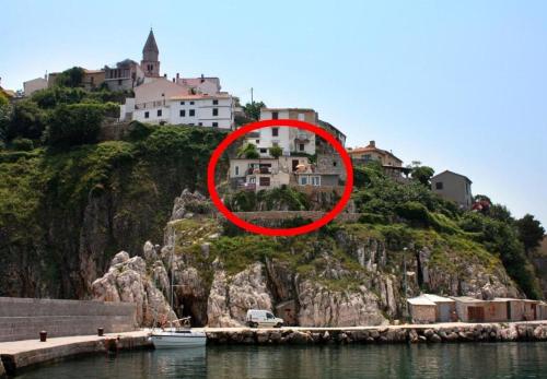 a house on a hill next to a body of water at House Bernardica in Vrbnik