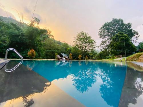 a pool with a reflection of a house in the water at EllaCrest by Aloft in Kumbalwela
