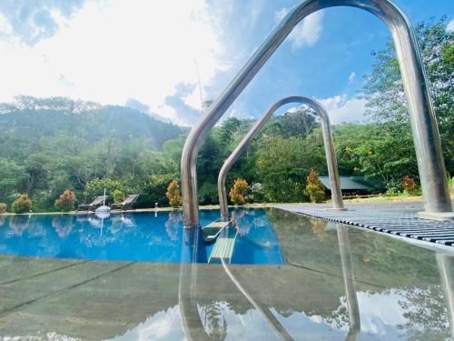 a swimming pool with a set of metal stairs leading to a swimming pool at EllaCrest by Aloft in Kumbalwela