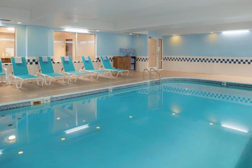 a swimming pool with blue chairs in a hospital at Fairfield by Marriott in Troy