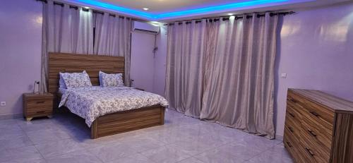 a bedroom with a bed and a large window at Villa Djiby in Somone